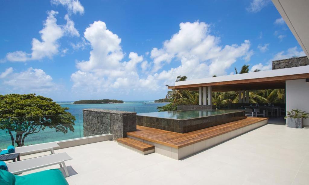 an outdoor patio with a view of the ocean at PentHouse sur mer - Blue Alizée in Blue Bay