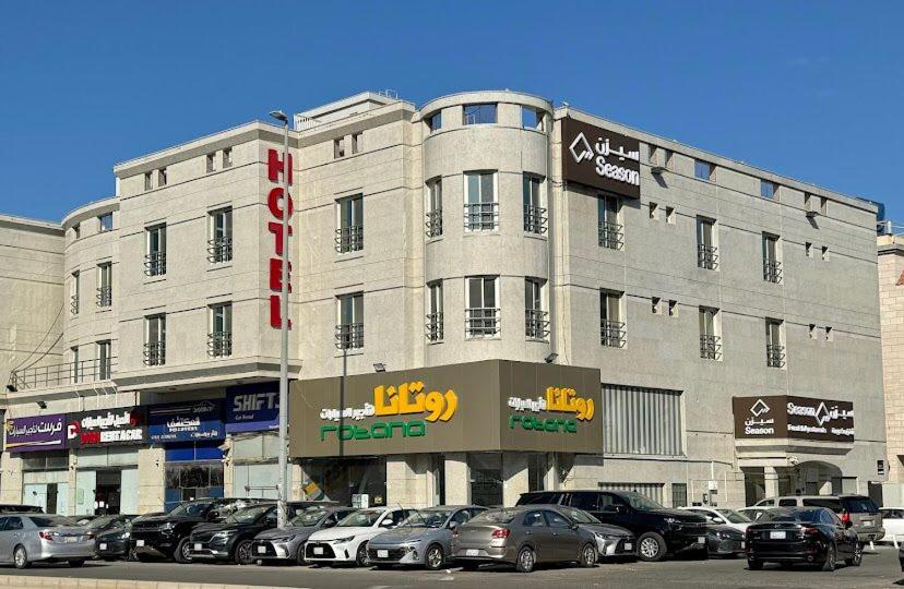 ein großes Gebäude, vor dem Autos parken in der Unterkunft سيزن للوحدات السكنية in Dschidda