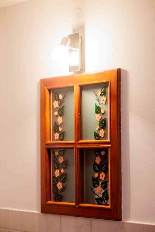 a wooden cabinet filled with wine bottles and flowers at Pansion Maltar Varaždin in Varaždin