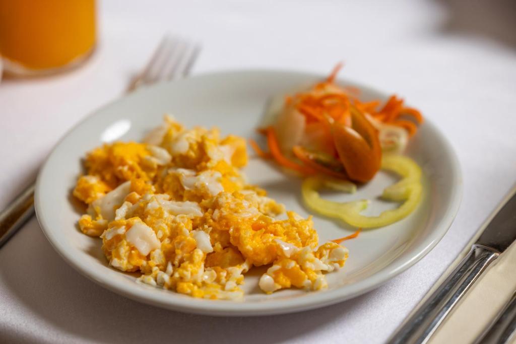 a white plate with food on a table at Pansion Maltar Varaždin in Varaždin