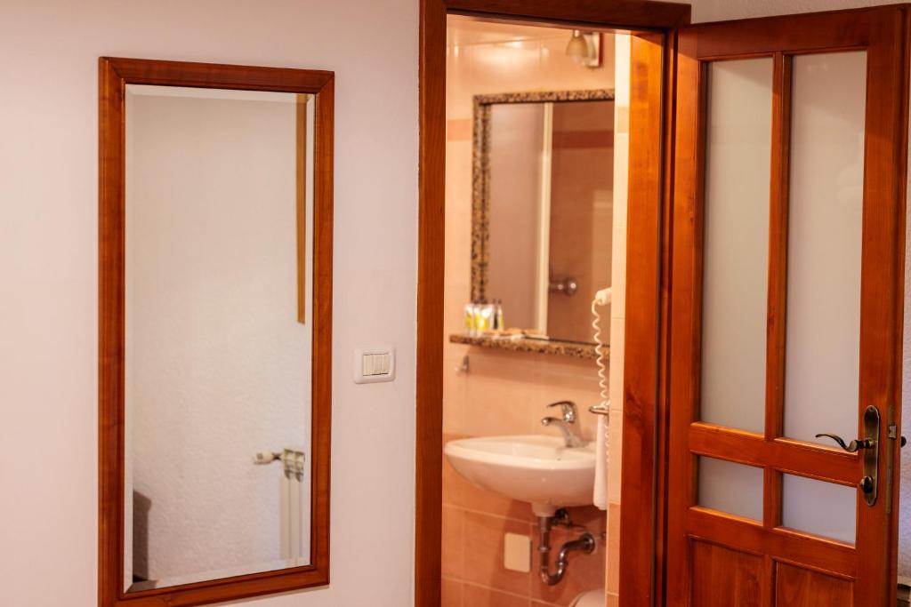 a bathroom with a sink and a mirror at Pansion Maltar Varaždin in Varaždin