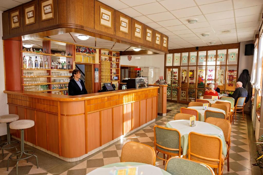 a woman standing at the counter of a restaurant at Pansion Maltar Varaždin in Varaždin