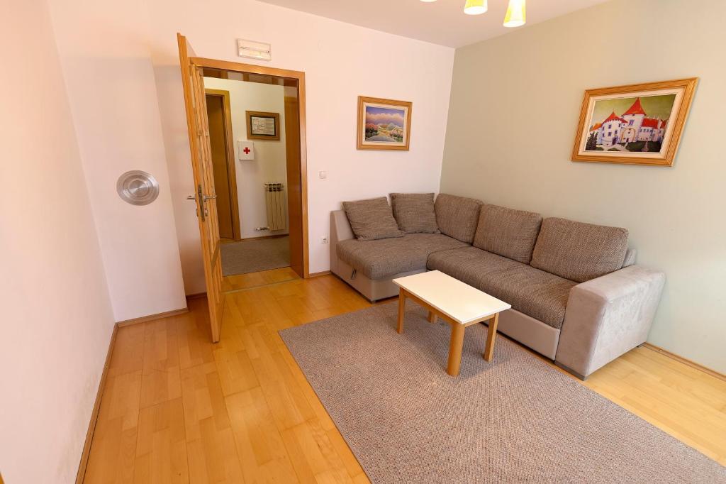 a living room with a couch and a table at Pansion Maltar Varaždin in Varaždin