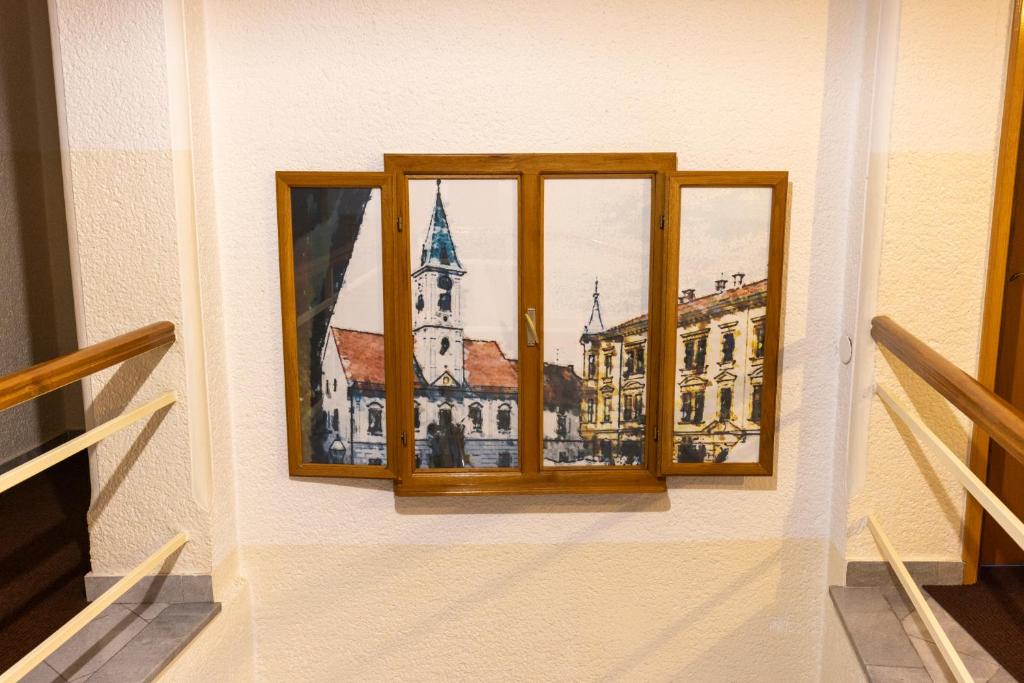 a window with a picture of a building at Pansion Maltar Varaždin in Varaždin