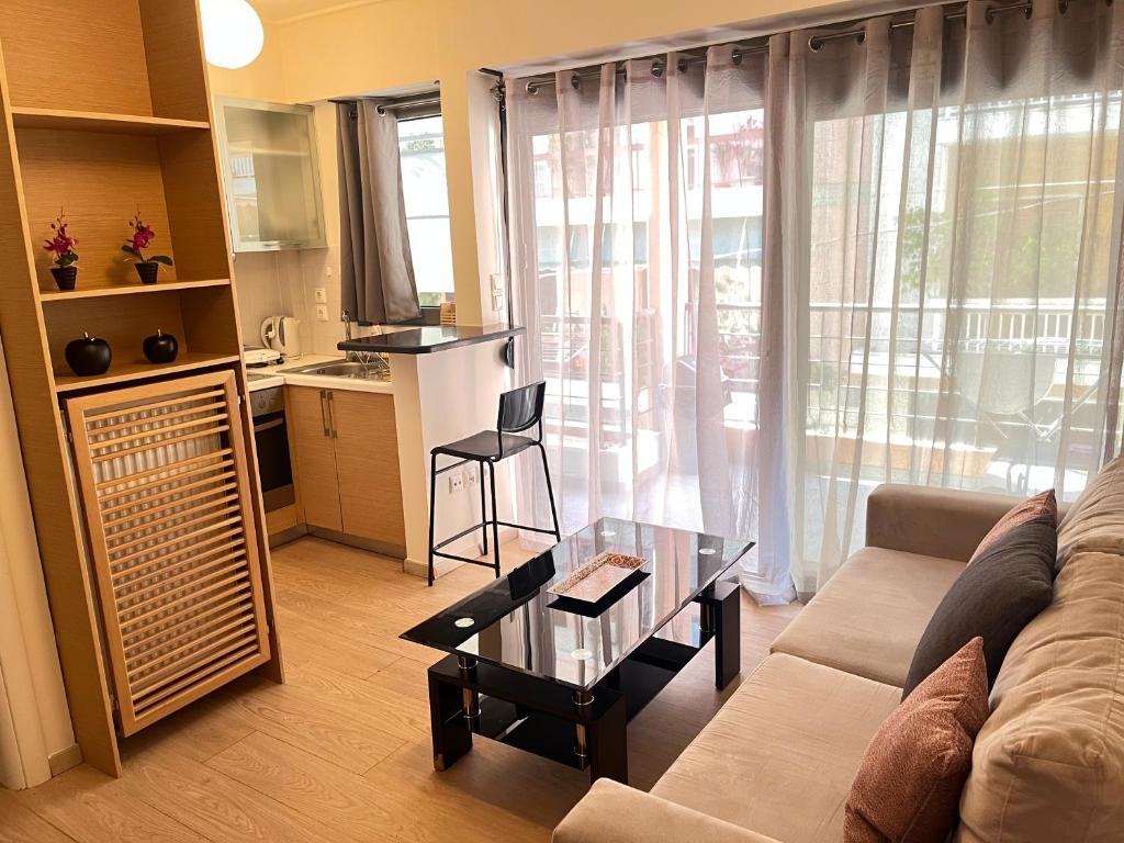 Elvita Apartments في أثينا: غرفة معيشة مع أريكة وطاولة