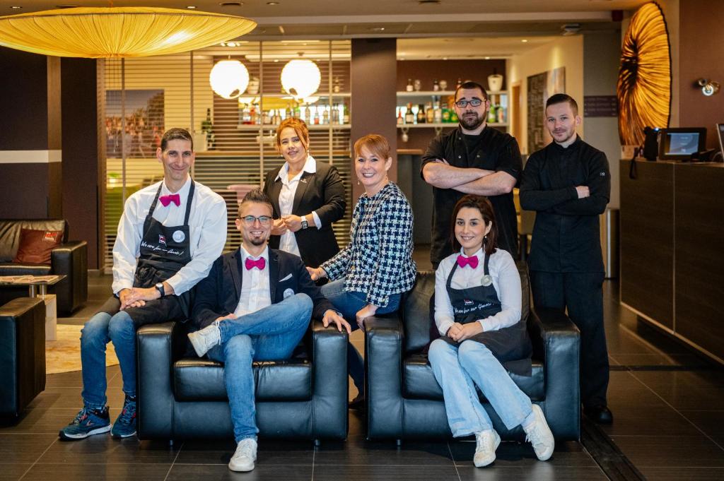 Un groupe de personnes pose une photo dans l'établissement Hotel-Restaurant Horizon Ath-Lessines, à Ghislenghien