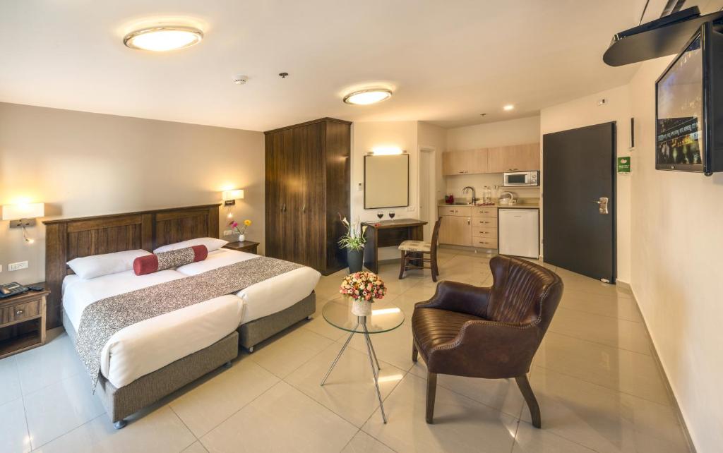 um quarto com uma cama e uma sala de estar em City Center Jerusalem em Jerusalém