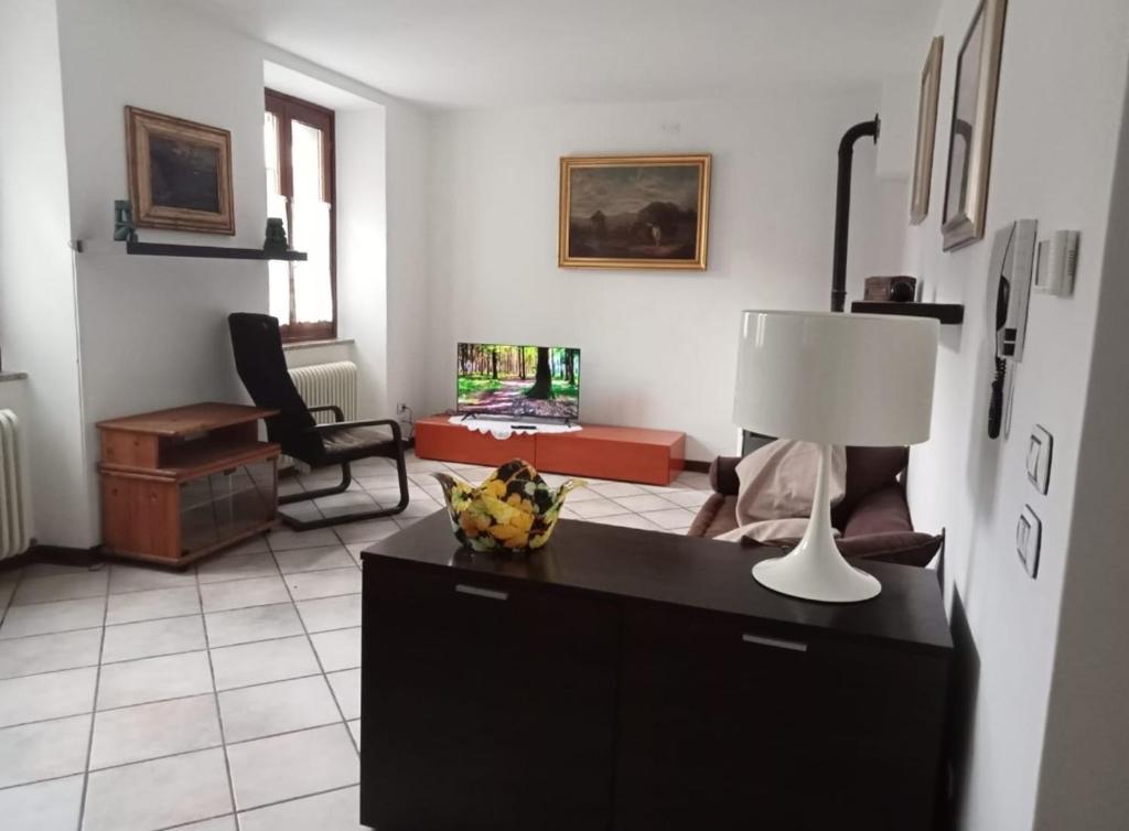 una sala de estar con una mesa con una lámpara. en APPARTAMENTO MIRTA, en Molina di Ledro