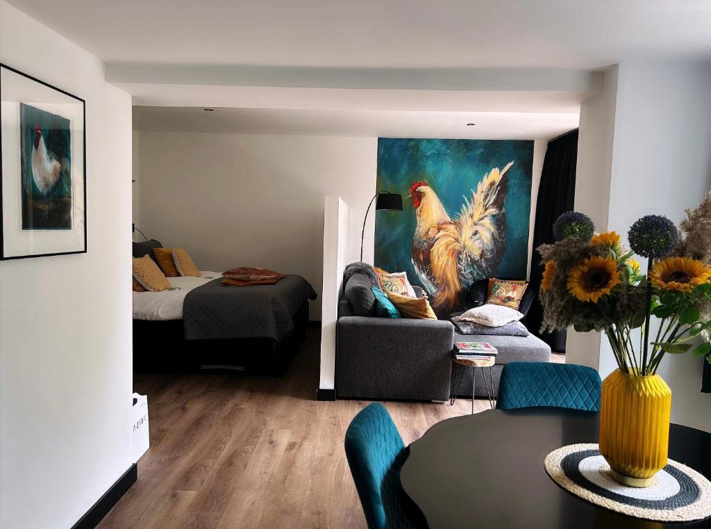 a living room with a couch and a painting of chickens at Het Blij Hoen in Oudenbosch