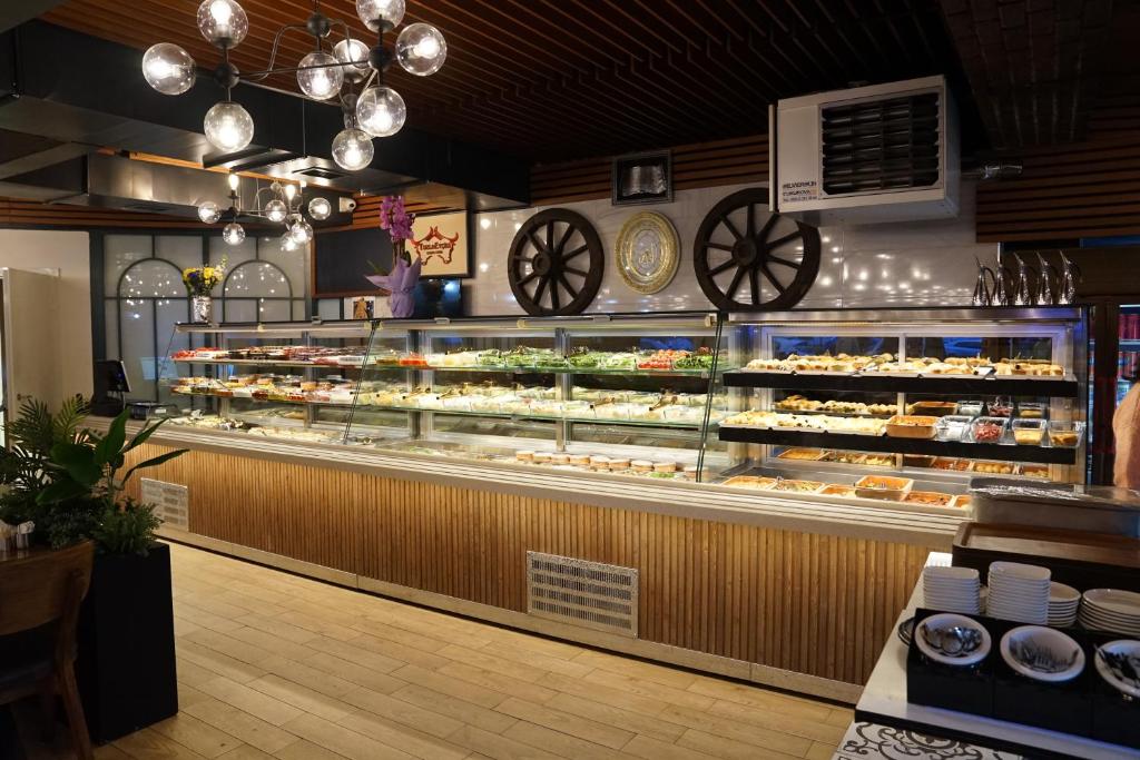 a bakery with a display case filled with pastries at Mihman Hotel in Tuzla