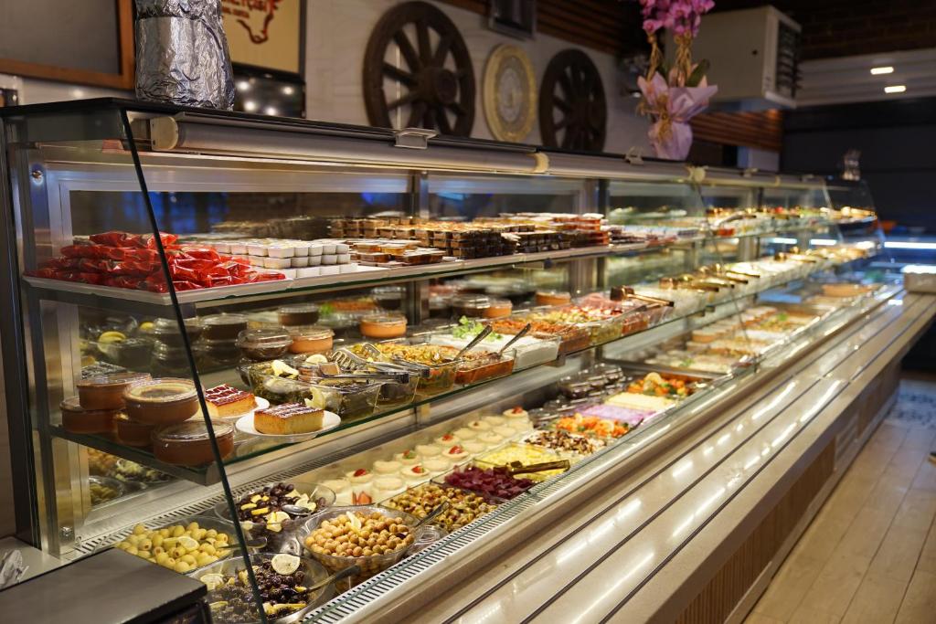 a display case filled with lots of different pastries at Mihman Hotel in Tuzla