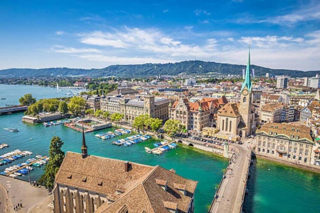 Luftblick auf eine Stadt mit Booten im Wasser in der Unterkunft Zürich 3 Zimmer Wohnung mit Dachterrasse in Zürich