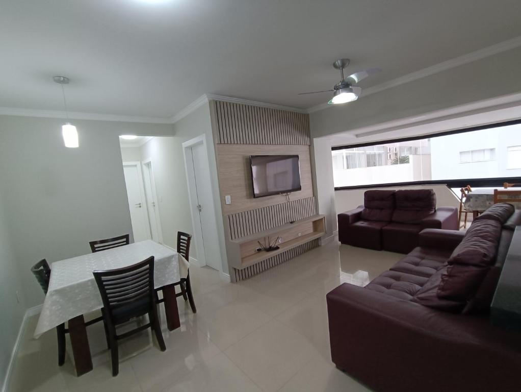 a living room with a table and a couch at Vista mar com ótima localização na meia praia in Itapema