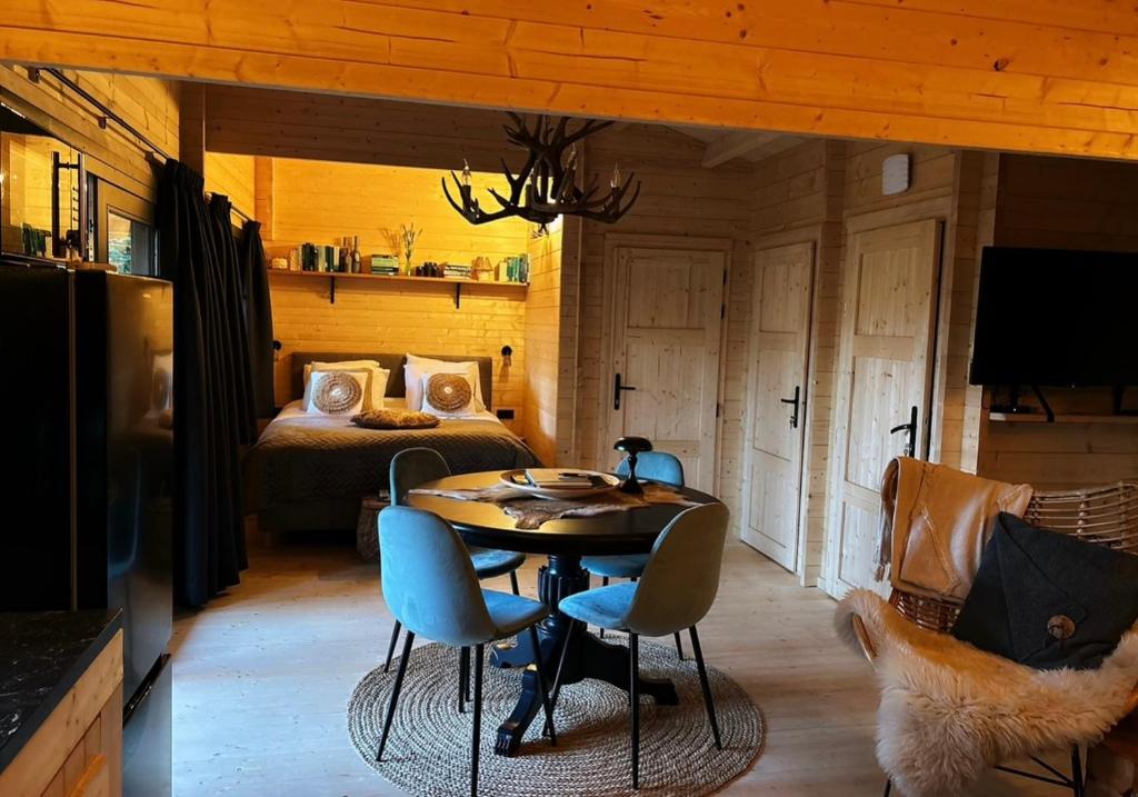 een kamer met een tafel en stoelen en een bed bij Het Blij Hen in Oudenbosch