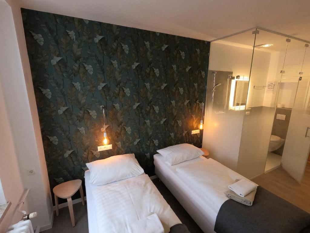 two beds in a room with a wall with butterflies at Landgasthof & Hotel Waldeck in Treuen