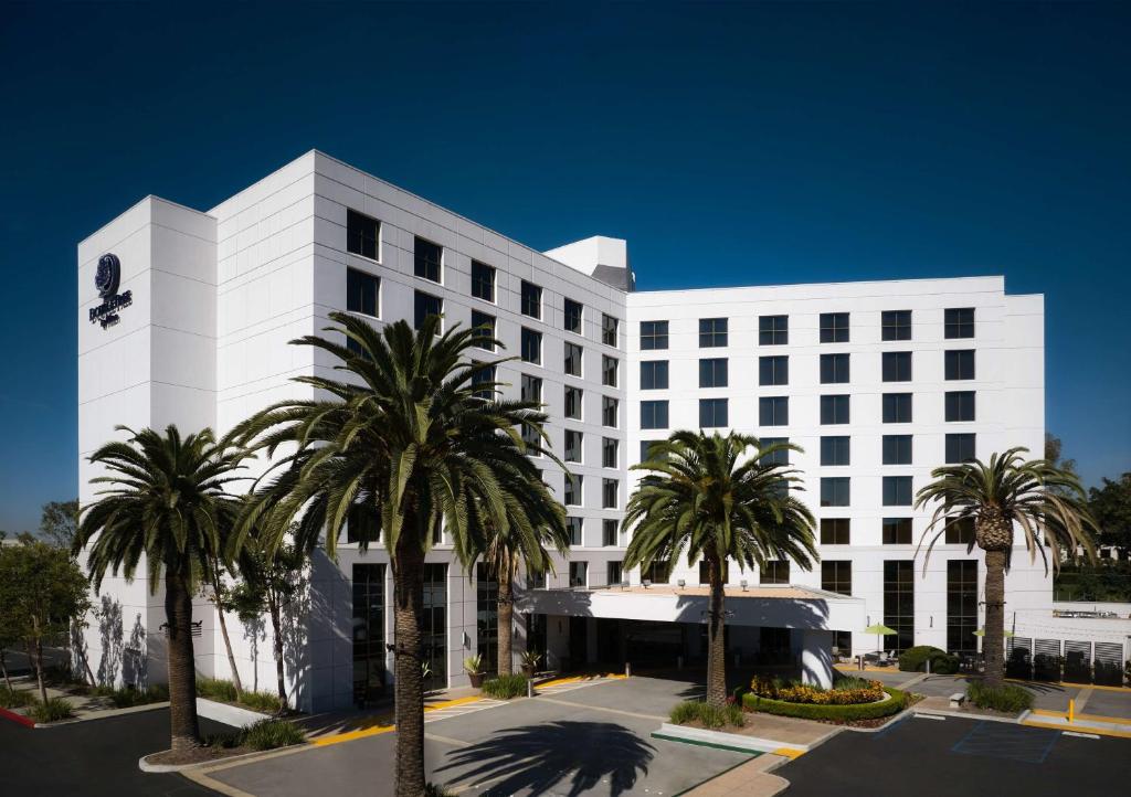 un bâtiment blanc avec des palmiers devant lui dans l'établissement DoubleTree by Hilton Irvine Spectrum, à Irvine