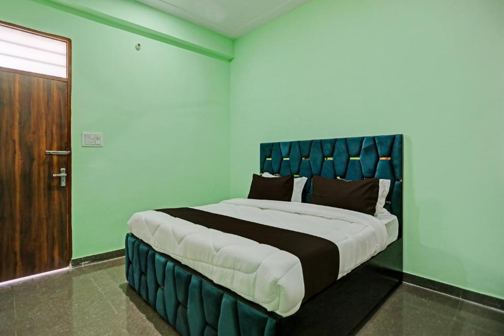 1 cama grande con cabecero azul en una habitación en OYO J M K Hotel en Gurgaon