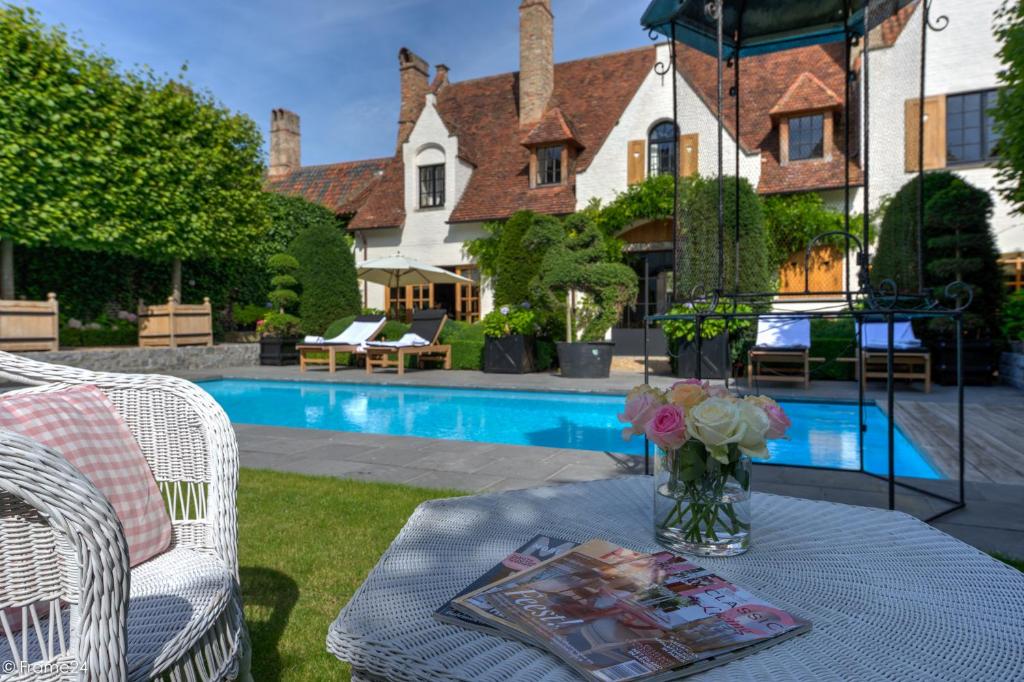 a garden area with a pool, table and chairs at Exclusive Suites The Secret Garden in Bruges