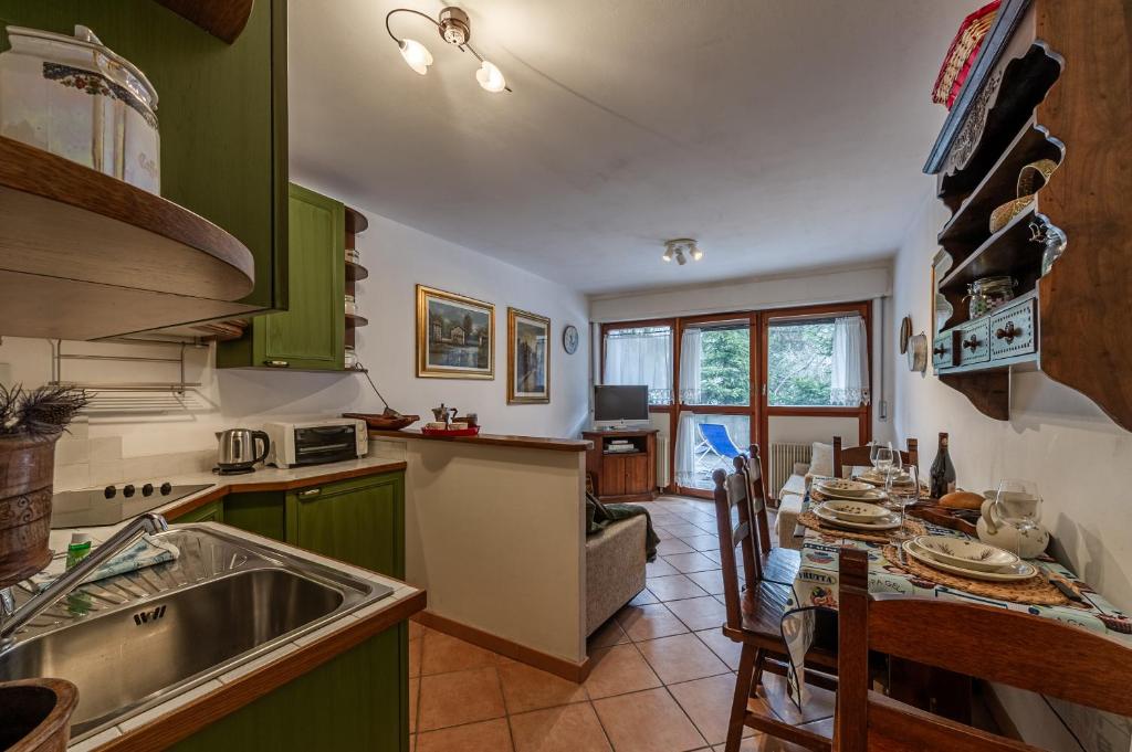 a kitchen with green cabinets and a table with chairs at APT PLANIBEL - Comfort sulle piste da SCI - LA THUILE 0086 in La Thuile