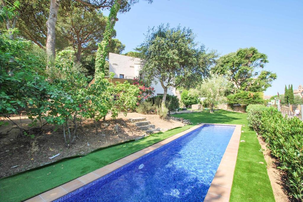 een zwembad in een tuin naast een huis bij Casa Can Pau in Begur