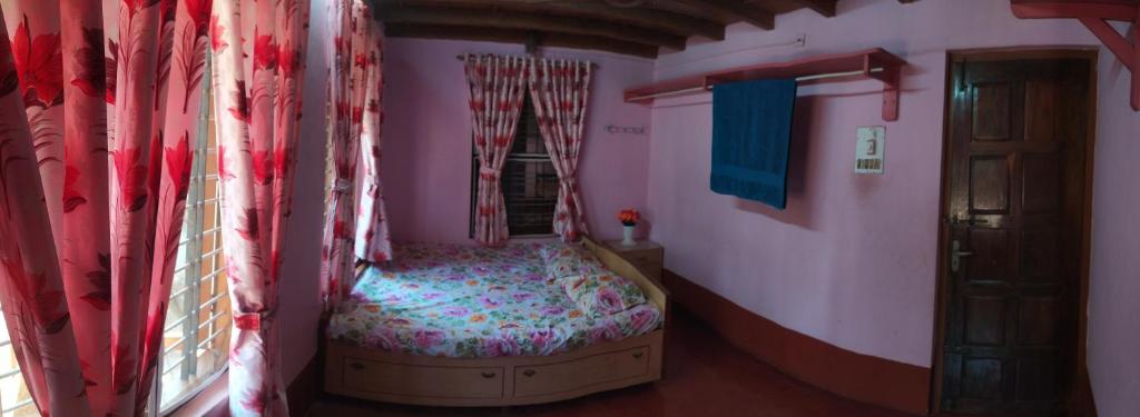a bedroom with a bed in a room with a window at Roam Alone Roomstay near International airport in Gurpur