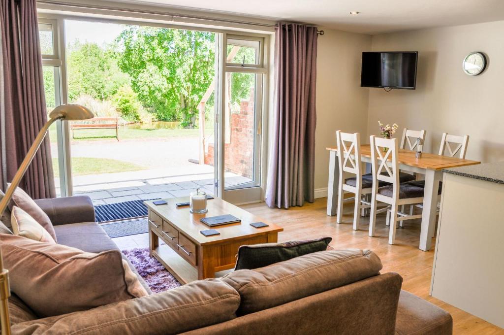 a living room with a couch and a table at Warbler Lodge in Droitwich