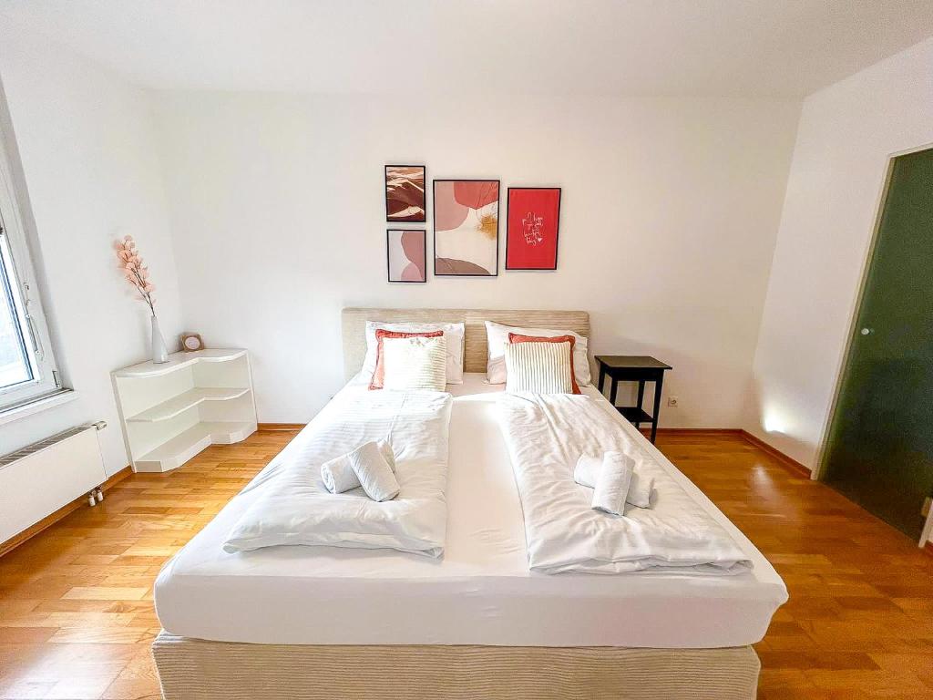 een slaapkamer met een groot wit bed met 2 kussens bij FeelHome-Prater-Ausblick-Terrasse-6 Gäste-WiFi-Smart TV in Wenen