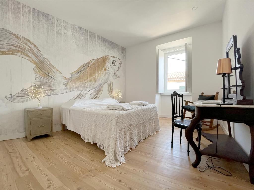 1 dormitorio con 1 cama con un mural de pescado en la pared en Casa Alta, en Castelo de Vide