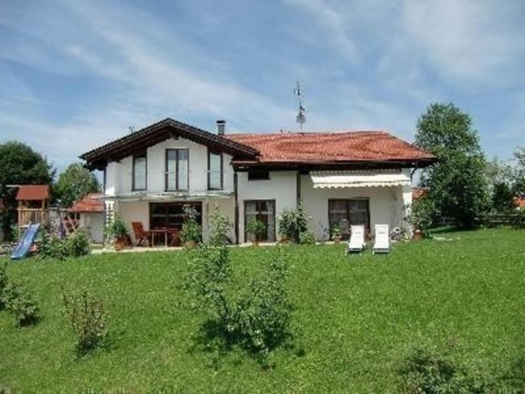 a house with two chairs in a yard at Ferienwohnung für 3 Personen in Bad Bayersoien, Bayern in Bad Bayersoien