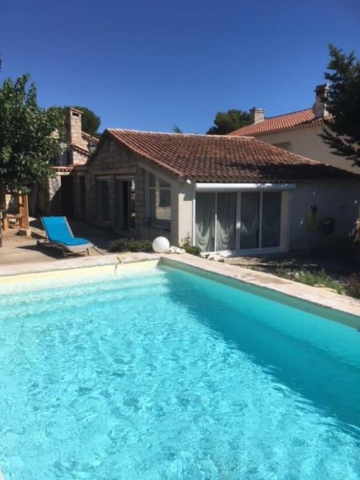 une grande piscine bleue devant une maison dans l'établissement Joli pavillon individuel, à Carry-le-Rouet