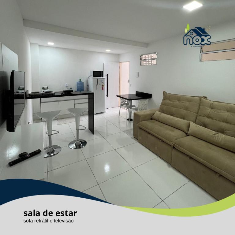卡魯阿魯的住宿－Nox Temporada - Flat 201 a 4km da Feira e Shopping Caruaru，带沙发和书桌的客厅
