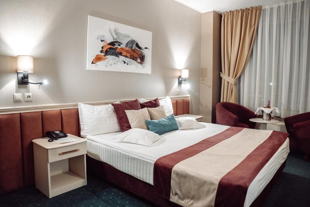 a hotel room with a bed and a chair at Unirea Hotel & Spa in Iaşi