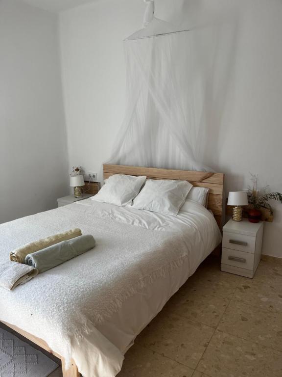 1 dormitorio con 1 cama grande con sábanas y almohadas blancas en Can Bastida, en Cardona