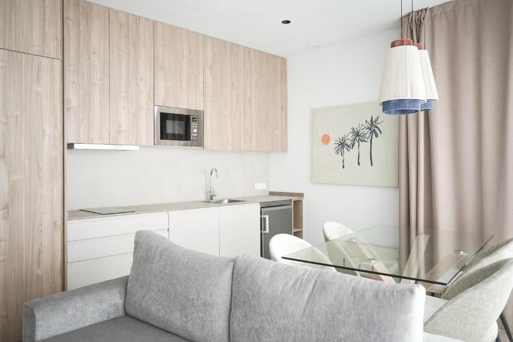 Lumen Mare by SH Hoteles في فالنسيا: غرفة معيشة مع أريكة وطاولة زجاجية