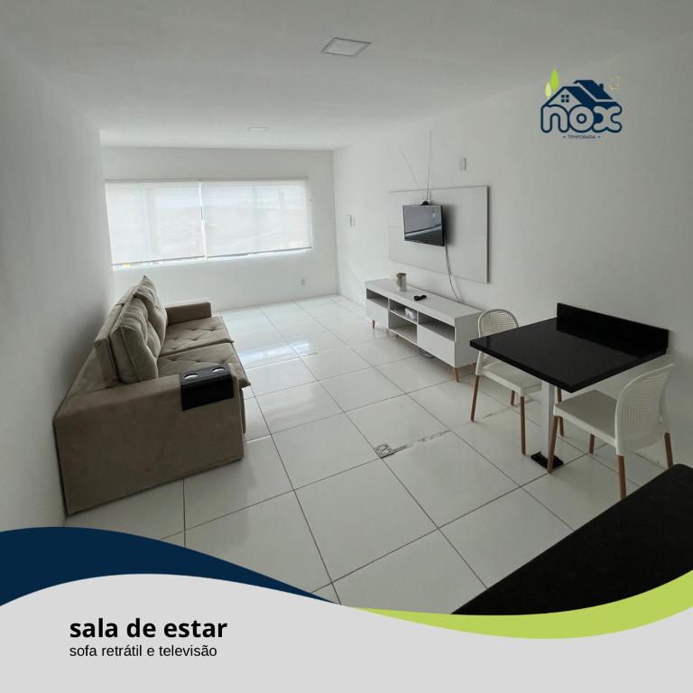 Nox Temporada - Flat 101 a 4km da Feira e Shopping Caruaru في كاروارو: غرفة معيشة مع أريكة وطاولة