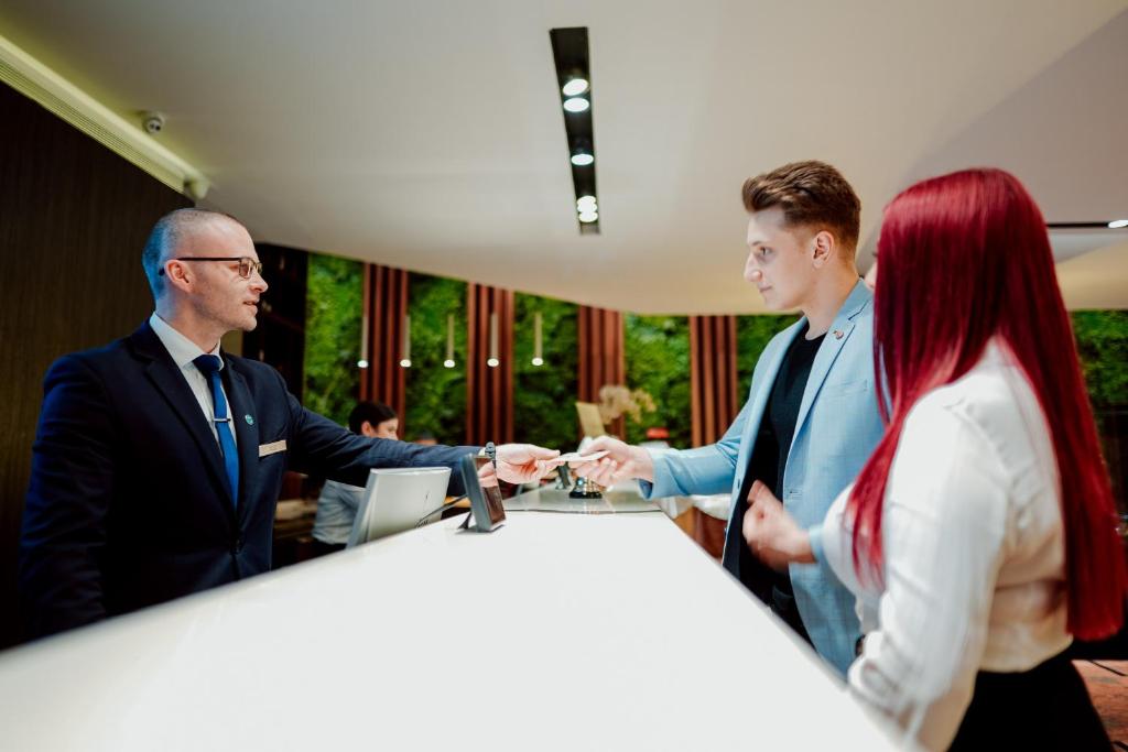 a group of three people standing around a table at Unirea Hotel & Spa in Iaşi