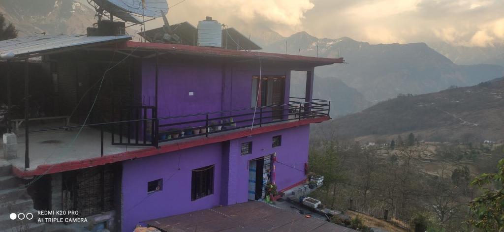 a purple building with a dog standing next to it at Nitwal Home Stay in Munsyari