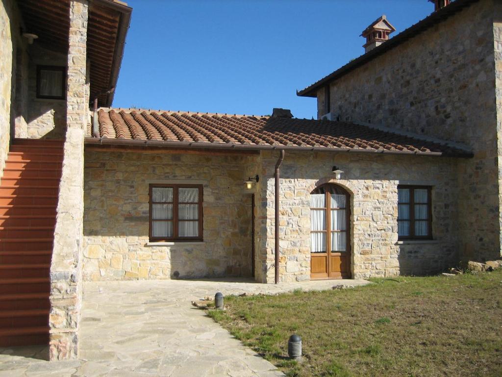 an old stone house with a brown door at Condominio Pisella in Pieve di Panzano