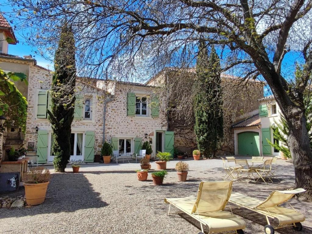 een binnenplaats met 2 stoelen en een huis bij Spacious holiday home with private pool in Cazouls-lès-Béziers