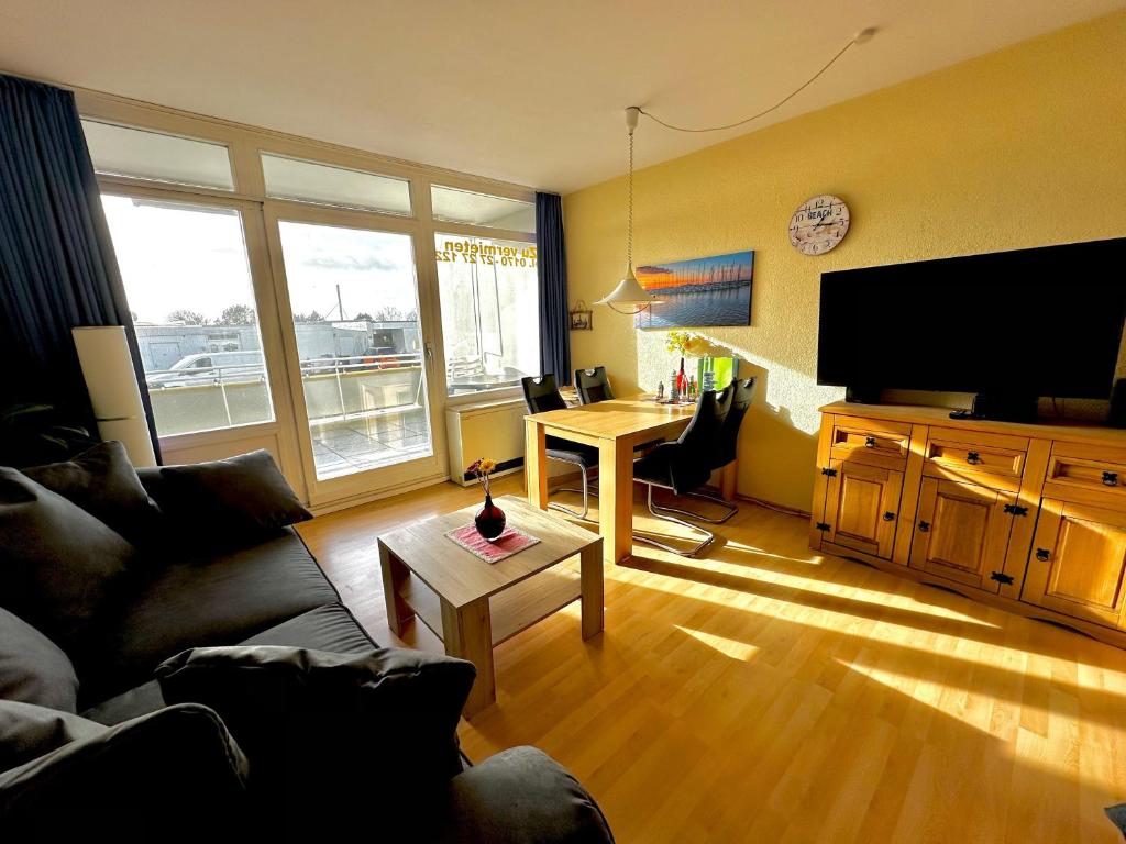 a living room with a couch and a table with a desk at Suedstrand-Ferienwohnung-Suhr in Burgtiefe auf Fehmarn 