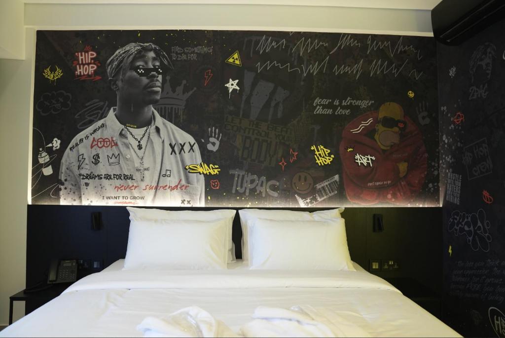 a bedroom with a bed with a wall with graffiti at SO City Hotel Adults Only in St. Julianʼs