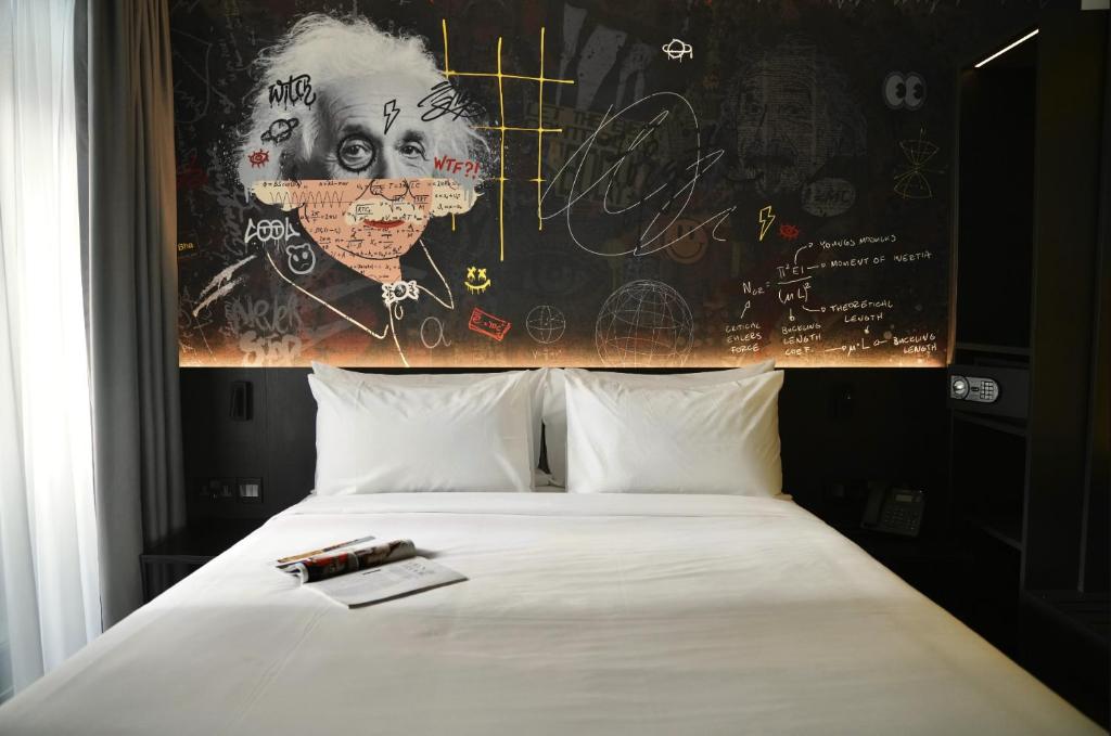 a bedroom with a bed with a painting on the wall at SO City Hotel Adults Only in St. Julianʼs