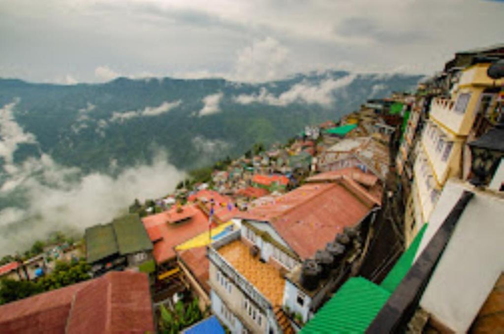 une vue aérienne sur une ville aux nuages dans les montagnes dans l'établissement HOTEL MOUNT ROYALE Darjeeling, à Darjeeling