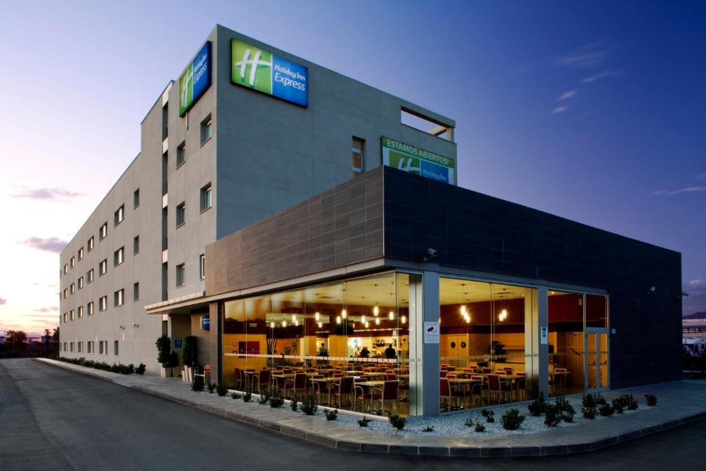 un gran edificio con mesas y sillas en Holiday Inn Express Málaga Airport, an IHG Hotel en Málaga