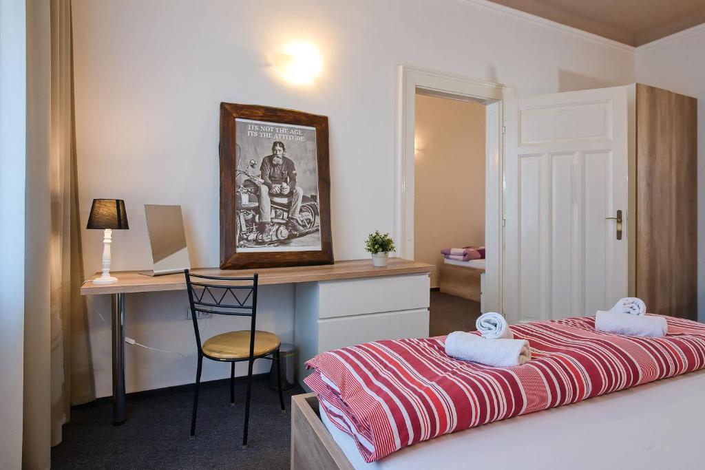 a bedroom with a bed and a desk with a chair at Stodolní Apartment in Ostrava