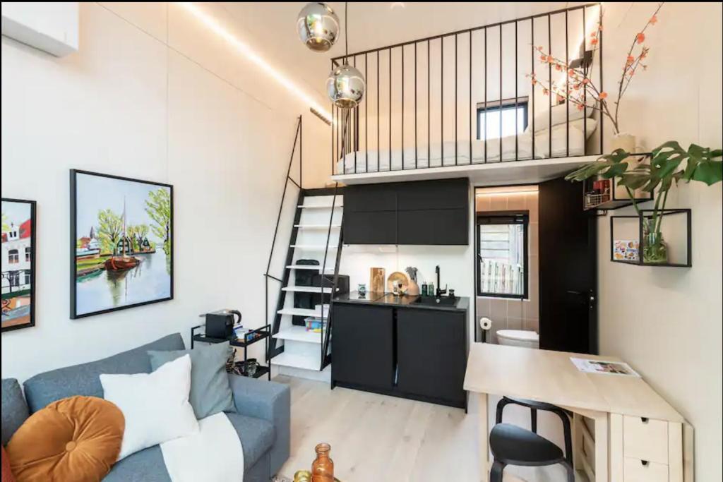 a living room with a blue couch and a kitchen at KODA Edam in Edam