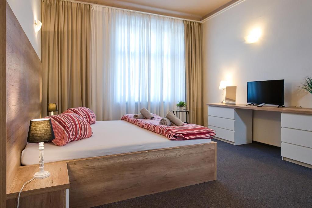 um quarto de hotel com uma cama com televisão e uma cama sidx sidx sidx em Stodolní Apartment em Ostrava