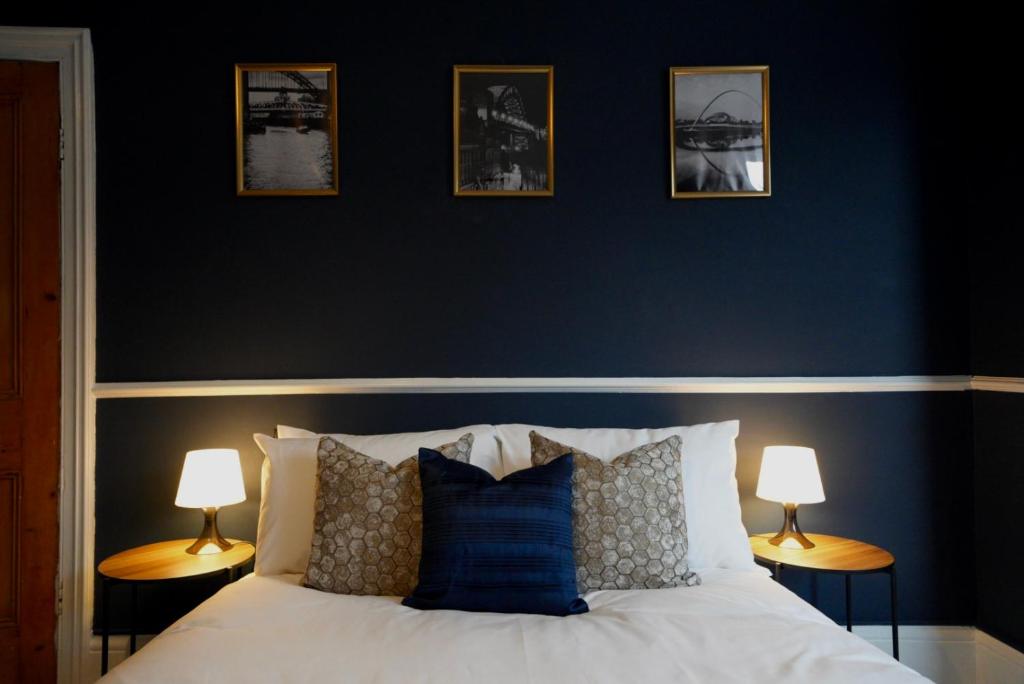 um quarto com paredes azuis e uma cama com almofadas em Centrally Located Stylish Flat em Jesmond