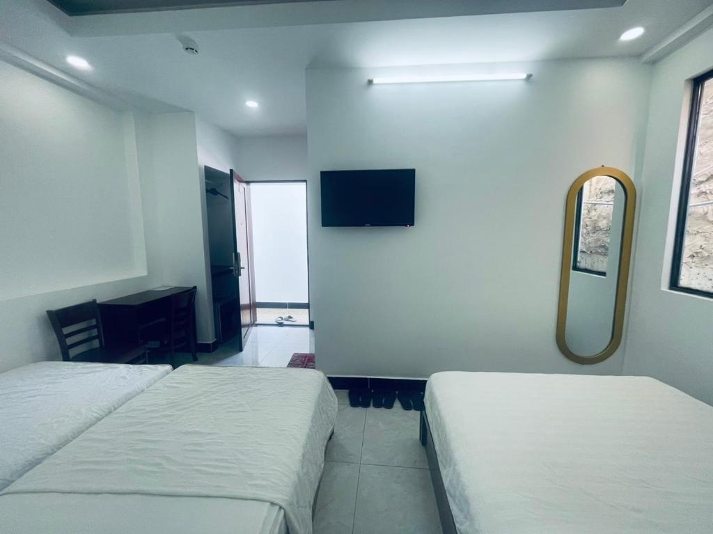 a hotel room with two beds and a mirror at T ONE II HOSTEL in Can Tho