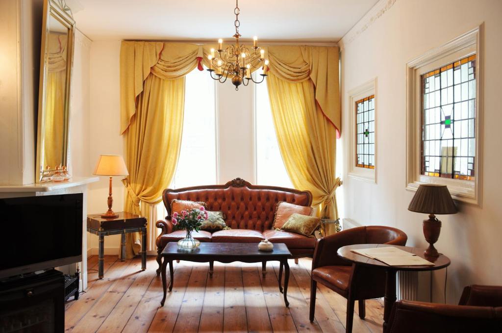 a living room with a couch and a large window at Hotel Schimmelpenninck Huys in Groningen